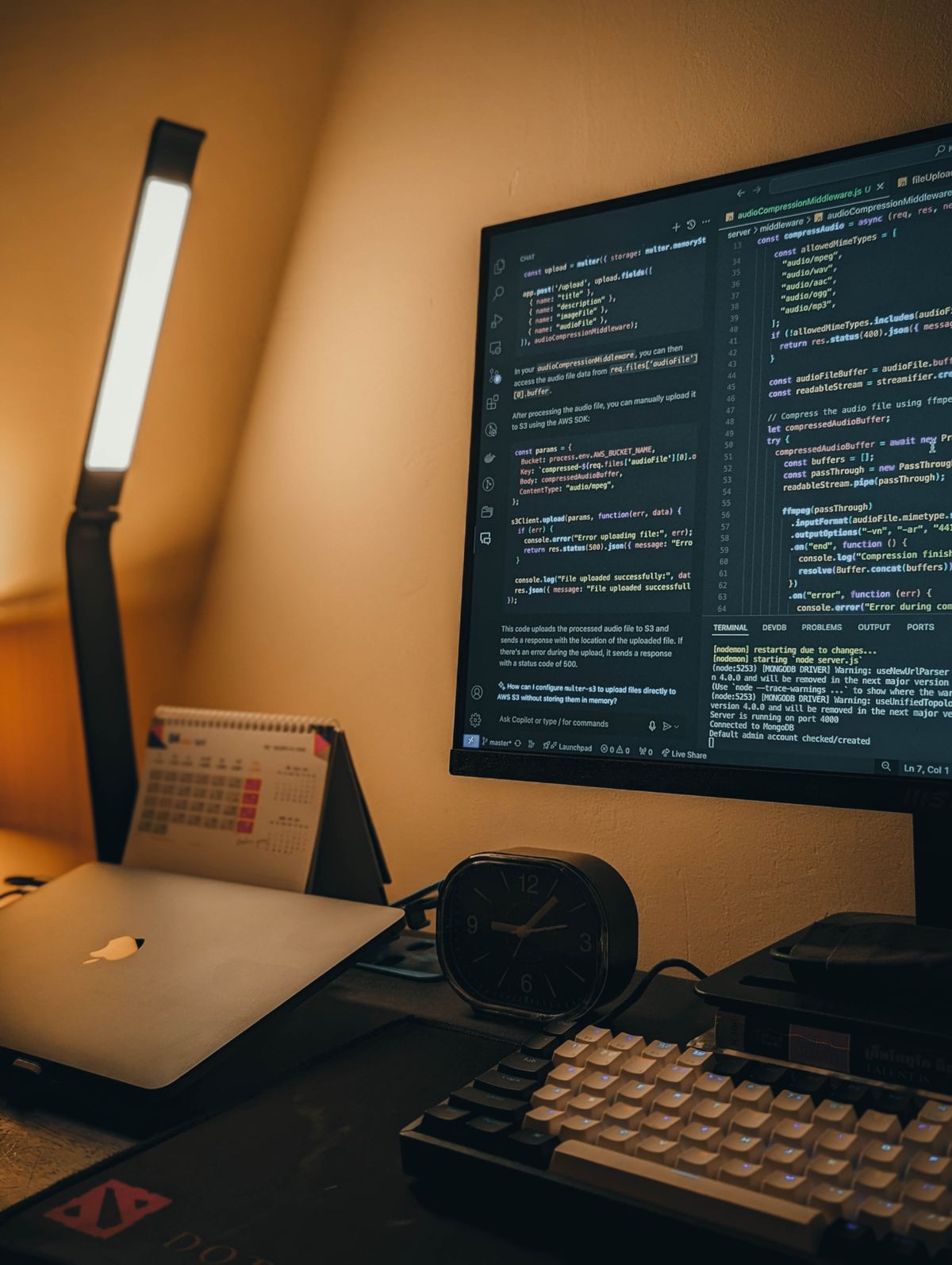 Monitor exibindo linhas de código sobre uma mesa de trabalho